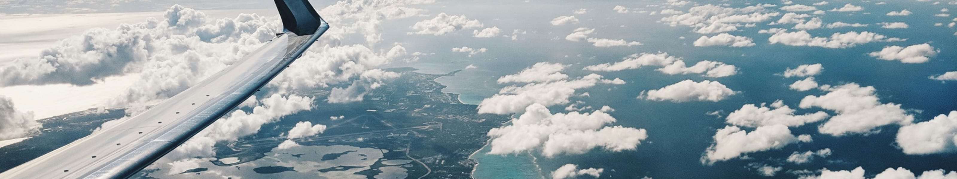 Aeroplane wing with clouds in the background